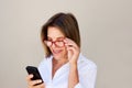 Close up businesswoman with glasses looking at cell phone