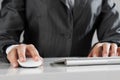 Closeup of businesswoman hand typing on keyboard with mouse on wood table Royalty Free Stock Photo