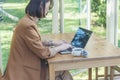 Close up businesswoman hand typing laptop drink black coffee cup in green garden cafe. Woman Hands love drinking hot coffee Royalty Free Stock Photo