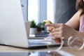 Close-up of businesswoman hands using smart phone while working on laptop Royalty Free Stock Photo