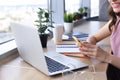 Close-up of businesswoman hands using smart phone while working on laptop. Royalty Free Stock Photo