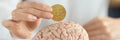 Businesswoman holding bitcoin coin in front of human brain