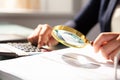 Businesswoman Examining Invoice Through Magnifying Glass Royalty Free Stock Photo