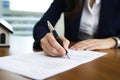 Close-up businesswoman signing contract at desk in office