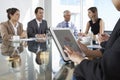 Close Up Of Businesswoman Using Tablet Computer During Board Meeting Around Glass Table Royalty Free Stock Photo