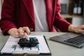 Close up of businesswoman working on calculator to calculate financial data report, accountancy document and laptop computer at Royalty Free Stock Photo