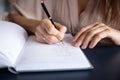 Close up businesswoman writing in notebook, planning workday, managing time