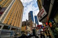 A close up of a busy New York street. Lots of shops and people on the streets.