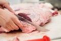 Close up of butcher caving piece of meat in butchers