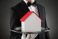 Close-up Of Butler With House Model Royalty Free Stock Photo