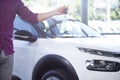 Close-up of buyer with keys in hand to new exclusive car in dealing salon