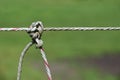 Close-up of a cable of an electric fence that is held together with a knot Royalty Free Stock Photo