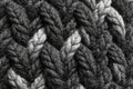Close-up of a cable knit fabric showcasing a repeating pattern of braids and textures in contrasting black and white Royalty Free Stock Photo