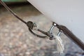 Close-up of a cable tie with a sea knot on an iron loop that holds the boat near the pier near the shore. Reliability, safety, Royalty Free Stock Photo