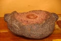 Close up of cacao beans milled over a stone mortar, in a wooden table background Royalty Free Stock Photo