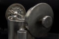 Close-up of Cafetiere plunger is placed on stainless steel jug  with a shallow depth of field on black background. French press Royalty Free Stock Photo