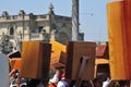 Close-up of a cajon, man\'s legs and hands are shown as he\'s playing the instrument in the square of lima peru