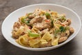 Close Up cajun chicken Fettuccine pasta in a creamy sauce on white plate ready to eat. Creole cuisine