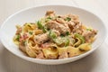 Close Up cajun chicken Fettuccine pasta in a creamy sauce on white plate on wooden table. American cuisine