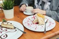 Close-up of a cake in a cafe. Adult mother and daughter at the table, drinking coffee and eating cakes. Attention is Royalty Free Stock Photo