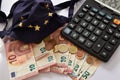 Close-up of a calculator, euro bills and diy facemask, designed as an Europian Union flag. Royalty Free Stock Photo