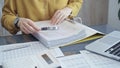 Close-up of a calculator with a female professional working with spreadsheets and a laptop on the background. Audit and