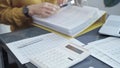 Close-up of a calculator with a female professional working with spreadsheets and a laptop on the background. Audit and