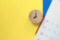 Close up of calendar, clock and pencil on the yellow and blue table background Royalty Free Stock Photo