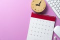 close up of calendar keyboard computer and alarm clock on the pink table background planning for business meeting or trave Royalty Free Stock Photo