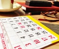 Close up of calendar page January 2021 on wooden table with glasses, tea cup, pen, diary Royalty Free Stock Photo