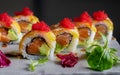 Close up of California Roll of Salmon, avocado, flamed cheese leaf and tobiko. Dark food