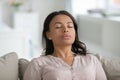 Calm biracial woman relax on sofa breathe fresh air Royalty Free Stock Photo