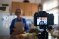 Close up of camera recording an old mature woman senior cooking and showing some recipes to her channel - youtuber job streaming