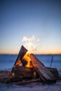 Close-up of a campfire burning on the beach at sunset with a clear sky Royalty Free Stock Photo