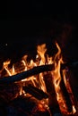 Close-up of a campfire. Fire burning brightly with a big yellow and orange flame in the dark. Firewood and logs burning to ember Royalty Free Stock Photo