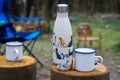 Close up of a campsite with cups on wooden stumps and empty seats in the background. Royalty Free Stock Photo