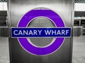 A close-up of the Canary Wharf, Elizabeth Line logo sign.