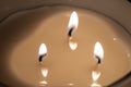 close-up of a candle with three lit wicks, creating a warm and relaxed atmosphere, flame of a triple wicks candle Royalty Free Stock Photo