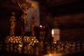 Close-up of candles on stand with candlesticks in front of crucifixion of Jesus, holy virgin Mary, apostle John.