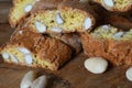 Close-up on cantucci or cantuccini on wooden background with shelled almonds. Cantuccini are typical Tuscan dry biscuits, made