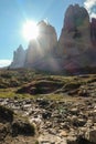 A close up capture of the peak of Tre Cime di Lavaredo (Drei Zinnen) in Italian Dolomites. The sun is hiding behind the high peak. Royalty Free Stock Photo