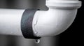 A close-up captures a leaking white pipe, highlighting a common plumbing problem. Royalty Free Stock Photo