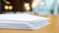 Stack of white papers on wooden table with blurry background Royalty Free Stock Photo