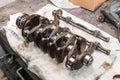 Close-up of a car crankshaft removed for replacement on a workbench in a vehicle repair shop. service industry