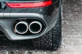 Close up of a car dual exhaust pipe parking lights, brake lights and wheel tires. Royalty Free Stock Photo