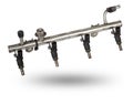 Close-up on a car fuel rail with injectors for supplying gasoline to a four cylinder engine on a white isolated background. Spare