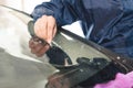 Close up Car glaze worker fixing and repairing a windshield or windshield of a car at a garage service station. Drill Royalty Free Stock Photo