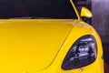 Close-up of Car Headlights of Yellow porsche sports car parked in the parking lot