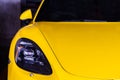 Close-up of Car Headlights of Yellow porsche sports car parked in the parking lot