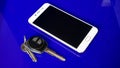 Close up car keys and cell phones with blue background Royalty Free Stock Photo